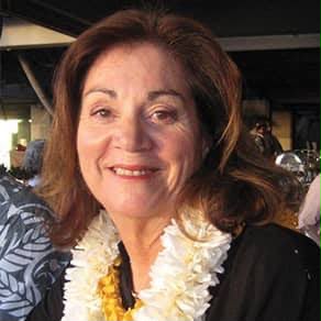 Color photo of Pokey Watson in later years, smiling and wearing a white flower lei